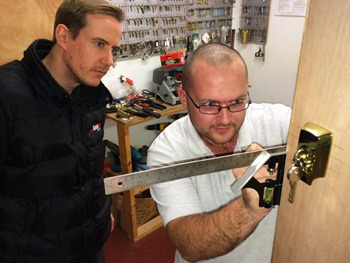 Locksmith fitting a lock in training